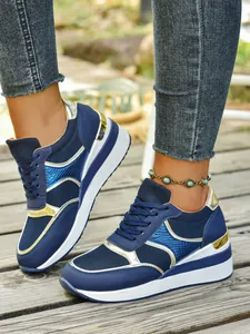 Λεπτομερής προβολή των μπλε sneakers πλατφόρμας με μεταλλικό patchwork και κορδόνια μπροστά.