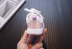Vista posterior detallada de zapatillas de cuero rosa y blanco para niñas pequeñas