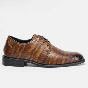 Vista laterale dettagliata di scarpe eleganti da uomo marroni con stampa coccodrillo
