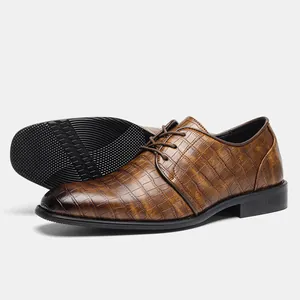Dettaglio scarpe eleganti marroni da uomo con motivo coccodrillo e suola esterna