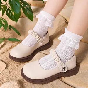 Elegante cremefarbene Mary Jane Schuhe aus Leder für Mädchen mit Spitzen-Socken auf Sand