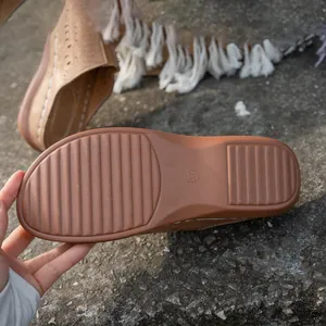 Close-up detail of the anti-slip rubber sole on brown cutout women clogs for summer