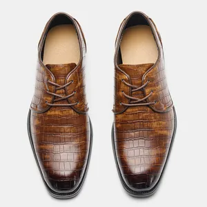 Vista dall'alto di scarpe eleganti da uomo in pelle marrone con trama a coccodrillo goffrata