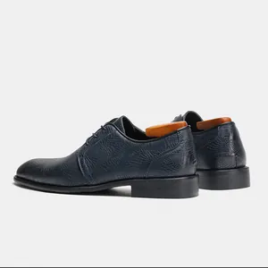 Vista dettagliata di scarpe eleganti da uomo blu navy con raffinata trama coccodrillo