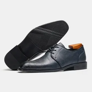 Dettaglio di scarpe formali da uomo blu navy con motivo a coccodrillo e suola antiscivolo