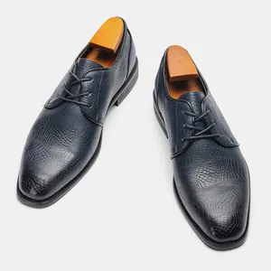 Vista dettagliata delle scarpe eleganti blu navy da uomo con trama a coccodrillo
