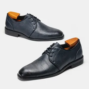 Primo piano di scarpe da uomo in pelle blu navy con stampa coccodrillo