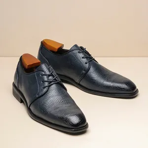 Primo piano di scarpe eleganti blu navy da uomo con texture in rilievo coccodrillo.