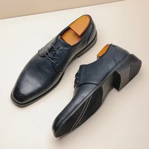 Dettaglio scarpe eleganti blu navy da uomo con raffinata trama in pelle di coccodrillo