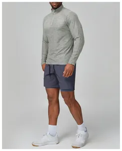 Male athlete wearing grey slim-fit long sleeve training top with quarter zip detail
