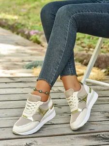 Κοντινό πλάνο από κομψά μπεζ και χρυσά sneakers με πλατφόρμα και τζιν σε εξωτερικό χώρο