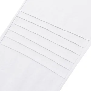 Detailed macro view of white linen men's pants featuring unique horizontal pleat textures.
