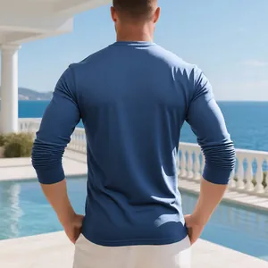 Back view of a premium men's long-sleeve cotton T-shirt in blue, outdoor poolside