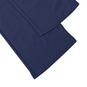 Close-up detail of navy blue linen pants showing wrinkled texture and clean hem stitching