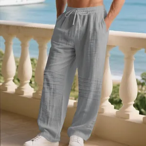Detail of men's loose gray linen pants with unique pleated design and drawstring waist