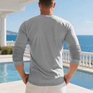 Back view of a man wearing a grey long-sleeved cotton T-shirt at a sunny poolside resort
