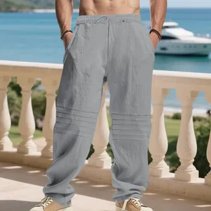 Men's grey linen drawstring pants with pleated knee detail in a loose fit beach style.