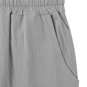 Detailed view of grey linen pants featuring an elastic waistband and side pocket.