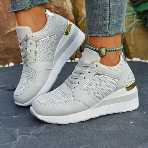Detail view of grey mesh platform wedge sneakers with gold metallic heel accents