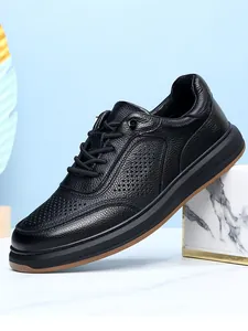 Detailed side view of men's breathable black leather shoes with premium perforated texture