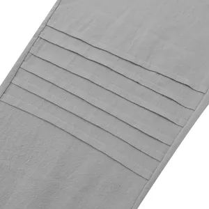 Macro detail of men's loose linen pants in grey showing horizontal pleated design elements