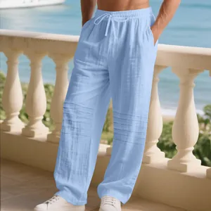 Detail of light blue men's loose linen trousers featuring pleated knees and drawstring.