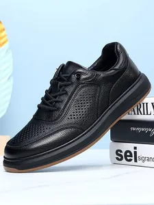 Detailed view of premium black leather men's casual shoes on a book prop