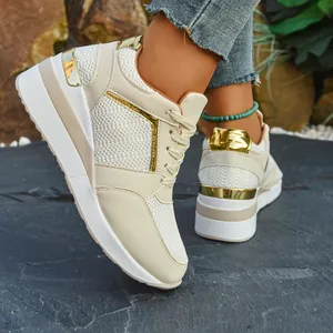 Close-up of women's beige wedge sneakers with gold accents and thick platform sole