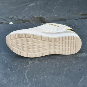 Close-up of the anti-slip textured outsole of these beige platform wedge sneakers