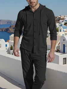 Casual men's black linen-look hooded shirt and trousers set in a scenic outdoor setting