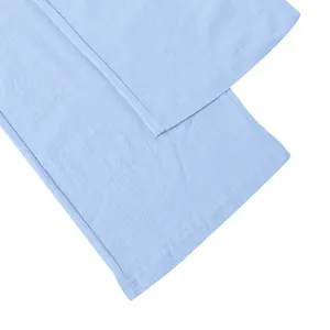 Detailed close-up of the leg hem on these light blue linen blend trousers for men.