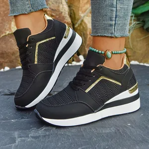 Stylish women's black and gold wedge sneakers with thick platform soles and mesh details