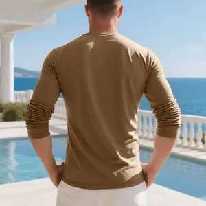 Back view of men's khaki textured long-sleeve cotton T-shirt by a scenic pool area