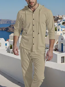 Close-up detail of men's beige linen hooded shirt and trousers set worn in outdoor setting