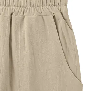 Detail shot of men's linen trousers showing elastic waist, side pocket and fabric texture.