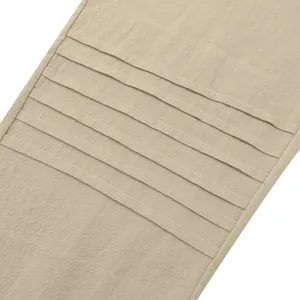 Macro detail of horizontal pleated design on beige linen-textured straight-leg trousers for men