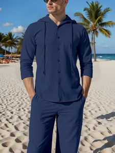 Detail view of navy blue long-sleeve hooded linen shirt and pants set on male model