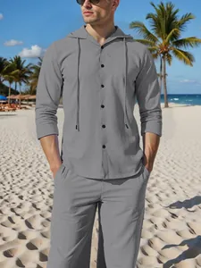 Detailed view of a man wearing a grey hooded linen-look long sleeve shirt and matching casual pants