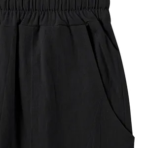Close-up of black linen pants showing textured elastic waistband and side pocket