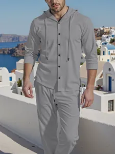 Men's grey linen hooded shirt and trousers casual set in a scenic coastal setting