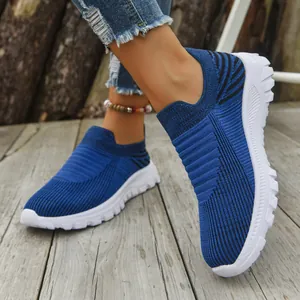 Stylish breathable blue flyknit slip-on sneakers for casual wear shown on a wooden deck