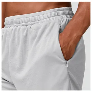 Detalle de pantalones cortos deportivos de malla gris transpirable para hombre con cremallera