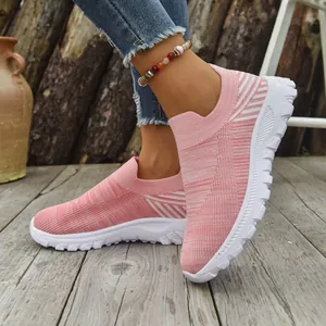 Detailed view of pink breathable fly-knit slip-on sneakers with chunky white soles