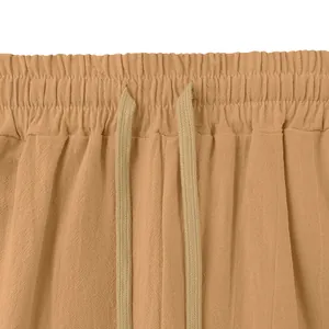 Detailed view of the elastic drawstring waistband on these loose men's linen pants.