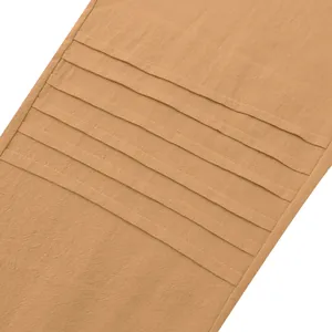 Detail of men's linen pleated trousers showing textured fabric and horizontal creases