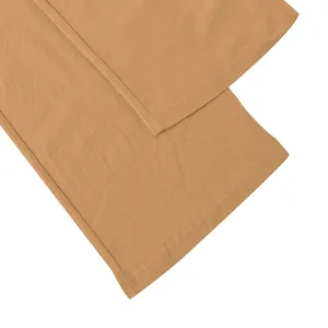 Detail shot showing the textured linen fabric and quality hem stitching on trousers