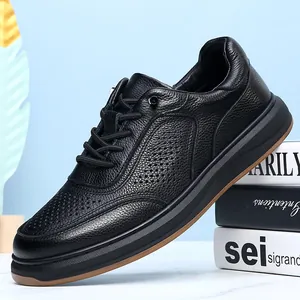 Detail view of men's black cowhide leather casual sneakers with breathable perforated design.