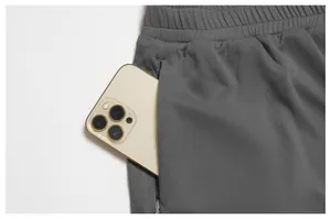 Detalle de pantalones cortos deportivos de malla gris con un teléfono en el bolsillo lateral