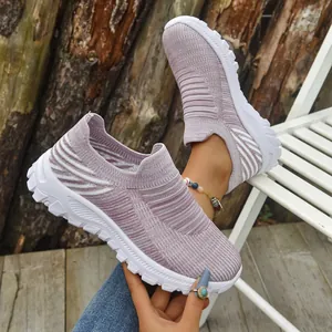 Close-up view of lavender breathable fly-knit slip-on sneakers with a chunky white sole.