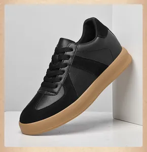 Professioneel zijaanzicht van zwarte Duitse trainers met rubberen zool en suède details